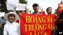 Vietnamese protesters carry a banner with a Vietnamese slogan reading, "Paracel islands and Spratly islands belong to Vietnam," during a protest demanding China to stay out of their waters following China's increased activities around the Spratly Islands 