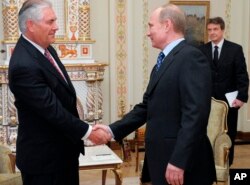 FILE - Russian Prime Minister Vladimir Putin, right, shakes hands with Rex Tillerson, chairman and chief executive officer of Exxon Mobil Corporation, at their meeting outside Moscow, April 16, 2012.