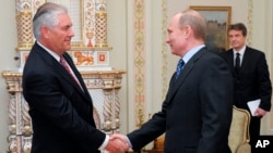 FILE - Russian Prime Minister Vladimir Putin, right, shakes hands with Rex W. Tillerson, chairman and chief executive officer of Exxon Mobil Corporation at their meeting in the in 2012. 