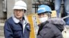 Los trabajadores de Sony trasportan los productos afectados por el tsunami en las bodegas del Puerto de Sendai.