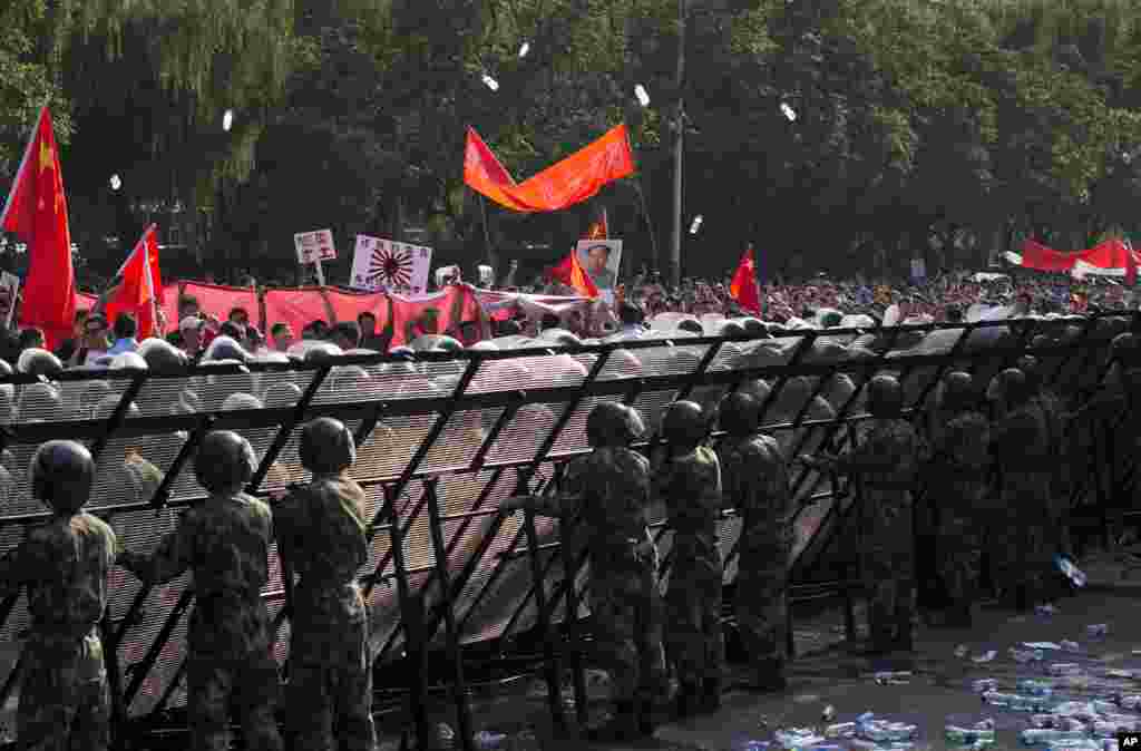 Anti-Japan protesters throws water bottles towards the Japanese Embassy during a protest in Beijing, China, September 16, 2012. 