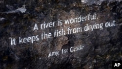 In this July 6, 2017 photo, words from a first grader are etched into a rock along the path to a section of newly formed beach, named Poet's Beach in Portland, Oregon.