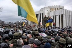 Protesters hold a Ukrainian national flag stand atop a blocked vehicle carrying former Georgian president Mikheil Saakashvili in Kiev, Ukraine, Dec. 5, 2017.