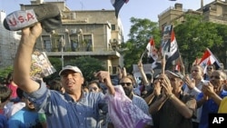 Pro-Syrian President Bashar Assad protesters shout slogans as they protest against the visit of the U.S. Ambassador to Syria Robert Ford to the Syrian city of Hama, in front the U.S. embassy in Damascus, Syria, July 8, 2011. Hundreds of thousands of Syria