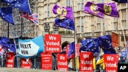 Manifestantes a favor y en contra del Brexit sostienen banderas frente al Parlamento británico en Londres el 3 de septiembre, de 2019.