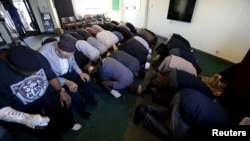 FILE - People pray at the Ahmadiyya Muslim Community Baitus-Salaam Mosque during an open mosque event at which members of the public are invited to see how Ahmadiyya Muslims pray, in Hawthorne, California.