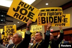 Supporters hold signs as former Vice President Joe Biden addresses the International Association of Fire Fighters in Washington, March 12, 2019.