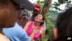 Margarita Mendez is helped by friends while she waits for news of her son Salvador Urbina, one of the miners trapped at El Comal gold and silver mine in Bonanza, Nicaragua, Aug. 29, 2014.