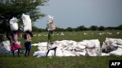 Des femmes portent des sacs de nourriture distribués par Oxfam à Padding, dans le Soudan du Sud, le 3 juillet 2017.