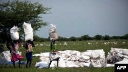 Des femmes portent des sacs de nourriture distribués par Oxfam à Padding, dans le Soudan du Sud, le 3 juillet 2017.