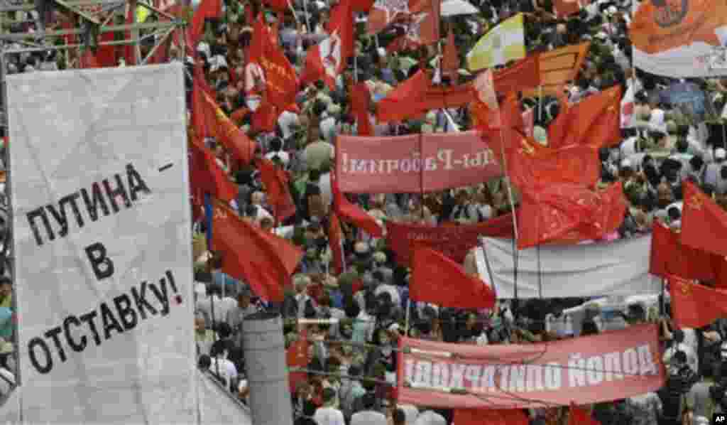 Demonstrators hold the flags of various groups during a massive protest against Putin's rule in Moscow, Tuesday, June 12, 2012. Thousands of Russians are gathering Tuesday for the first massive protest against President Vladimir Putin's rule since his ina