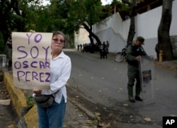 A women who said she was a supporter of rebel police officer Oscar Perez holds a poster that reads in Spanish "I am Oscar Perez" at a checkpoint near the morgue where his body is held, in Caracas, Venezuela, Jan. 17, 2018.