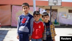 Displaced Iraqi boys pose at the Bilad al-Arab Elementary School, which has been turned into a housing complex for almost 31 families who fled Mosul because of Islamic State violence, in Baghdad, Oct. 22, 2014.