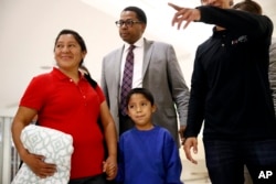FILE - Darwin Micheal Mejia, bottom center, and his mother, Beata Mariana de Jesus Mejia-Mejia, left, are escorted to a news conference following their reunion at Baltimore-Washington International Thurgood Marshall Airport, June 22, 2018, in Linthicum, Md.