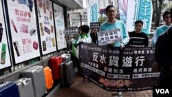 香港民主黨反水貨客遊行途經多個水貨客黑點，有店舖外擺滿疑似水貨客運貨的行李篋。(美國之音湯惠芸)