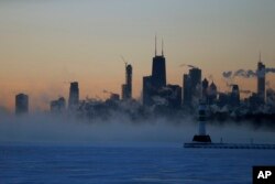 Ice forms along the shore of Lake Michigan before sunrise, Jan. 31, 2019, in Chicago, Illinois.