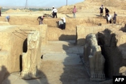 FILE - Iraqi workers in 2001 clean an archeological site in Nimrud. The Islamic State group has bulldozed the ancient Assyrian city, Iraq's government says, March 5, 2015.