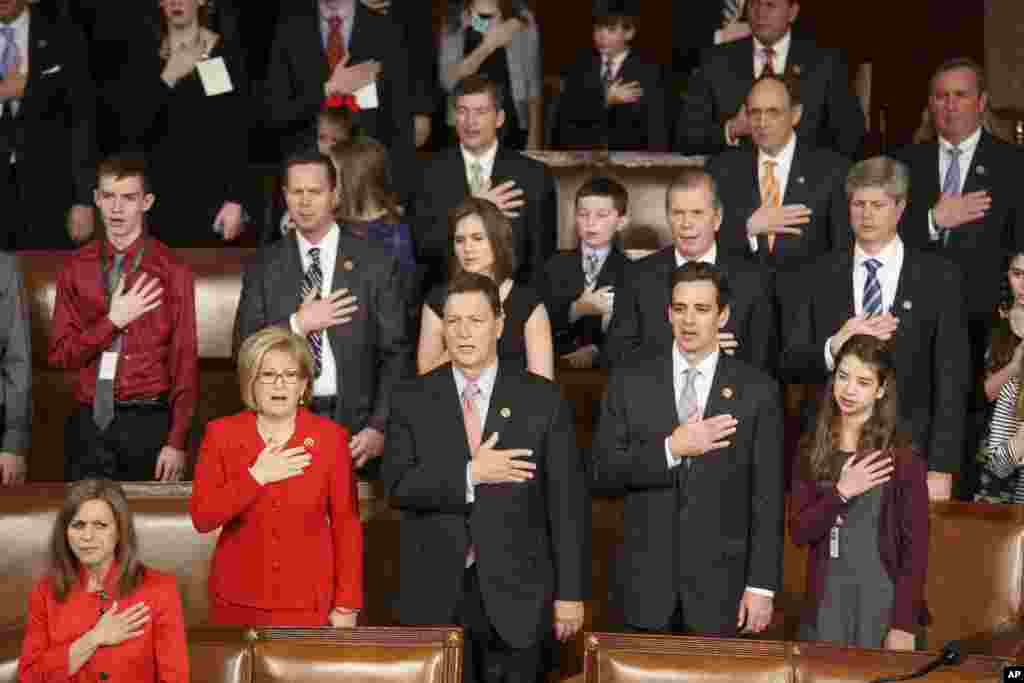 Members of the House of Representatives, many with their families, stand for the Pledge of Allegiance as they gather for the opening session of the 114th Congress on Capitol Hill in Washington, Jan. 6, 2015.