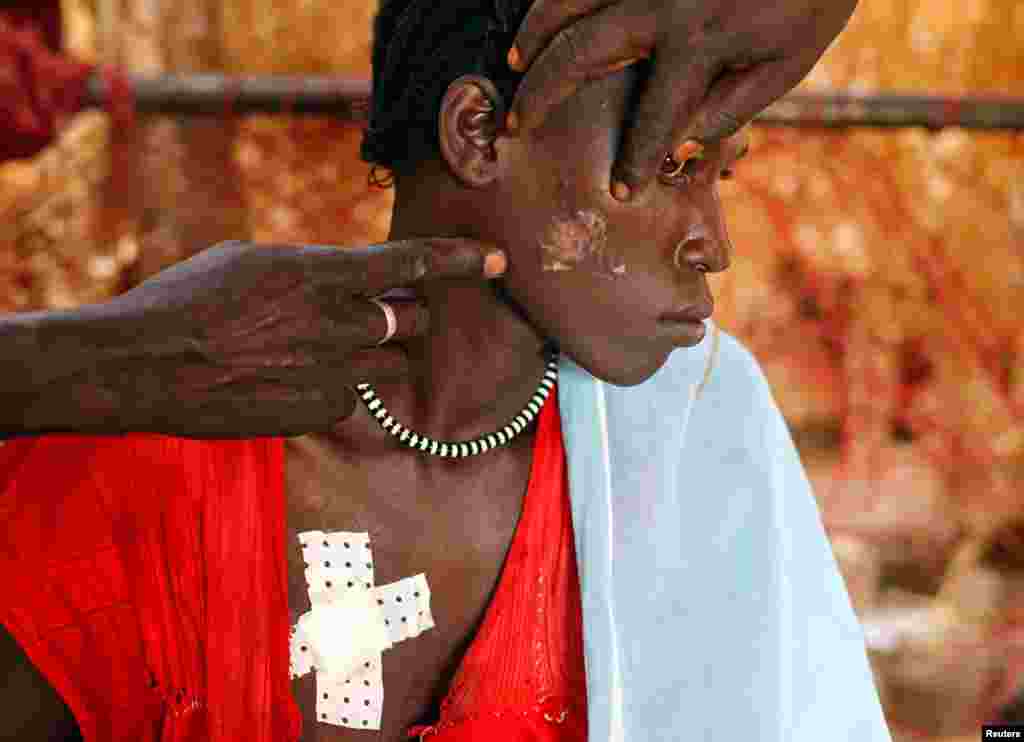 April 28: A Nuba woman, wounded during a raid by Sudan's air force, sits in a makeshift hospital in South Kordofan, Sudan.