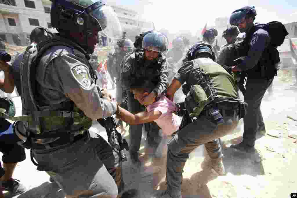 اسرائیل میں ایک مظاہرے کے دوران پولیس ایک فلسطینی شخص کو پکڑ کر لے جا رہی ہے۔