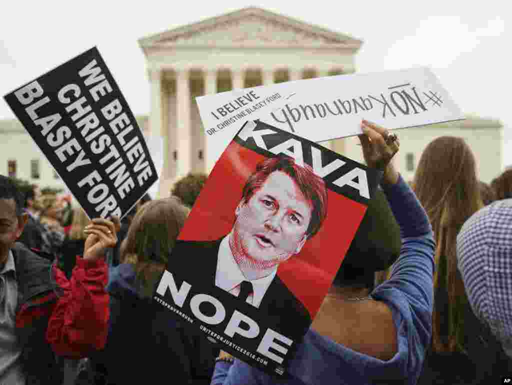 Para pengunjuk rasa berkumpul di depan Mahkamah Agung memegang gambar Calon Hakim AS Brett Kavanaugh dengan tulisan &quot;Kava Nope&quot; (Kava Tidak) dalam aksi menentang pencalonan Kavanaugh di gedung Capitol, Washington DC.