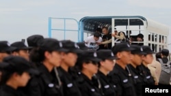 Tim SWAT polisi China berbaris sebagai tersangka penipuan telekomunikasi tiba sebelum deportasi mereka ke China di Bandara Internasional Phnom Penh, Kamboja 24 Juni 2016. (Foto: dok).