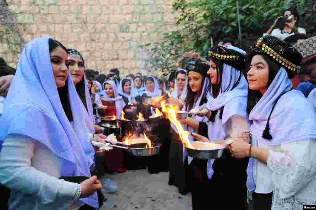 Iraqi Yazidis light candles and paraffin torches during a ceremony to celebrate the Yazidi New Year at Lalish temple in Shikhan in Dohuk province, Iraq, April 17, 2018.