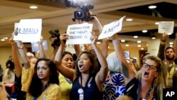 Manifestantes gritan a la presidenta del Comité Nacional Demócrata, Debbie Wasserman Schultz, a su llegada a una reunión con la delegación de Florida en la Filadelfia, el lunes, 25 de julio de 2016.