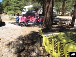 Los Angeles residents John and Pauline Barba tidy up their campsite in Flagstaff, Ariz., May 24, 2016. The charcoal grills were off-limits because of extreme fire danger, and portions of the nearby national forest closed.