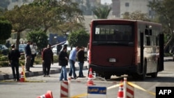 2013年12月26日，开罗发生爆炸事件后，埃及安全官员检查被炸坏的公共汽车。