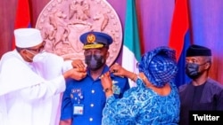 Buhari yana sakawa shugaban hafsan sojin sama aninai (Hoto: Twitter Nigerian Air Force)