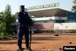 A police officer stands guard outside the quarantined Pasteur Clinic in Bamako, Mali on Nov. 12, 2014.