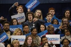 Los partidarios del aspirante presidencial demócrata de EE.UU., senador Bernie Sanders, reaccionan a sus felicitaciones por el candidato rival Joe Biden mientras Sanders habla en su mitin nocturno primario en Carolina del Sur en Virginia Beach, Virginia, el 29 de febrero de 2020.