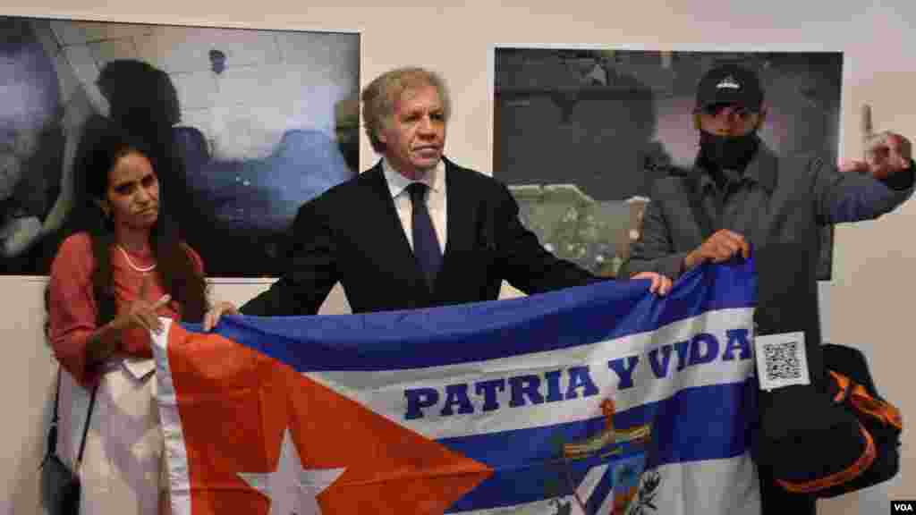 Anamely Ramos y Eliecer Márquez junto al secretario de la OEA, Luis Almagro con la bandera de Cuba estampada con los lecturas de la resistencia en el exilio. (Foto VOA / Tomás Guevara)