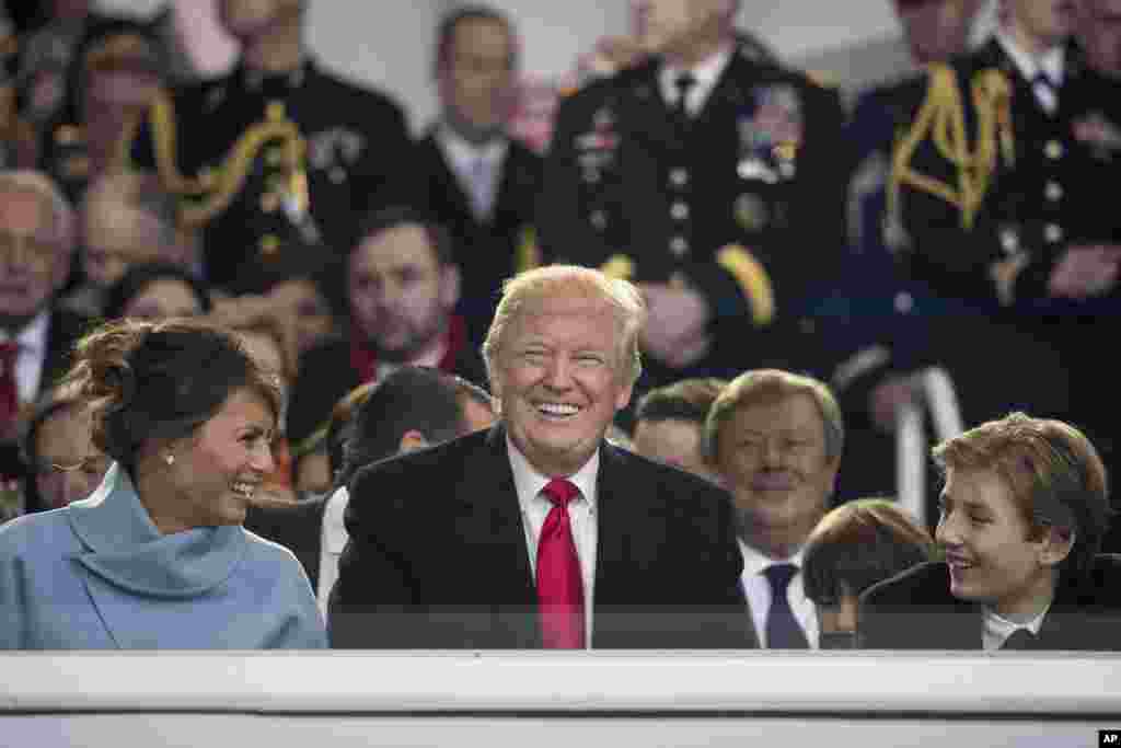 President Donald Trump shares a laugh with first lady Melania Trump and son Barron Trump as they sit in the reviewing stand during Trump's inaugural parade on Pennsylvania Avenue outside the White House in Washington, Jan. 20, 2017.