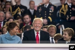 President Donald Trump shares a laugh with first lady Melania Trump and son Barron Trump as they sit in the reviewing stand during Trump's inaugural parade on Pennsylvania Avenue outside the White House in Washington, Jan. 20, 2017.