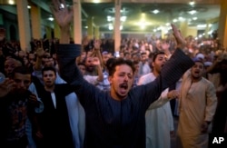 Coptic Christians shout slogans during a funeral service for victims of a bus attack, at Abu Garnous Cathedral in Minya, Egypt, May 26, 2017.