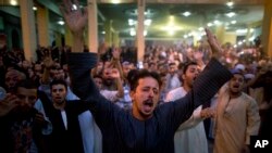Coptic Christians shout slogans during a funeral service for victims of a bus attack, at Abu Garnous Cathedral in Minya, Egypt, May 26, 2017.