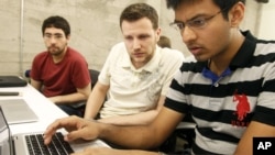 Shiva Gopalan, an international and computer engineering master's student at Texas A&M University (far right), confers with IBM developers Henrique Copelli Zambon (center) and Luiz Aoqui, during an IBM hosted Spark Hackathon at Galvanize, a tech hub in San Francisco on Sunday, June 14, 2015. (George Nikitin/Feature Photo Service for IBM)