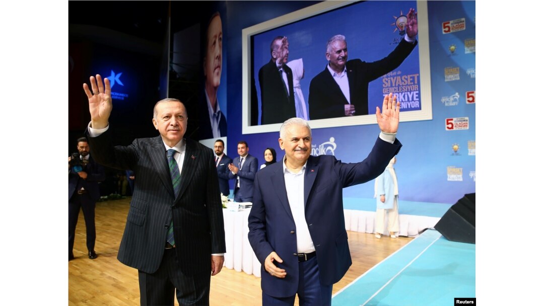 FILE - Turkish President Recep Tayyip Erdogan and Prime Minister Binali Yildirim greet their supporters during a meeting of the ruling AK Party in Istanbul, Turkey, April 29, 2018.