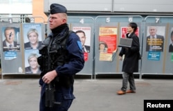 A policeman stands near a polling station during the first round of 2017 French presidential election in Henin-Beaumont, France, April 23, 2017.