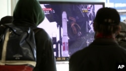 South Koreans watch a TV news program about North Korea's rocket launch plans at Seoul Railway Station in Seoul, S. Korea, Dec. 9, 2012.