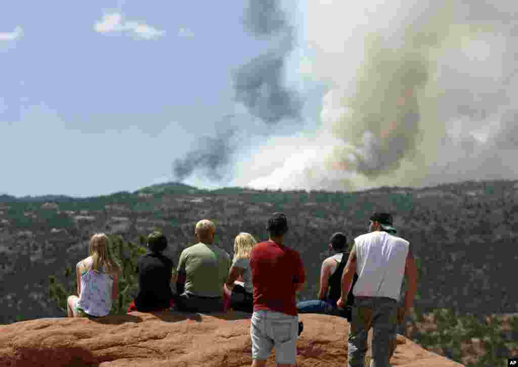 Warga setempat menonton asap yang mengepul akibat kebakaran hutan di sebelah barat kota Colorado Springs.