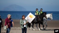   Protesters arrive at the beach near the Trump Golf Club in Tumberry, Scotland on Saturday 