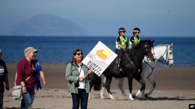 Manifestantes llegan el sábado a la playa cerca al club de golf de Trump en Tumberry, Escocia.