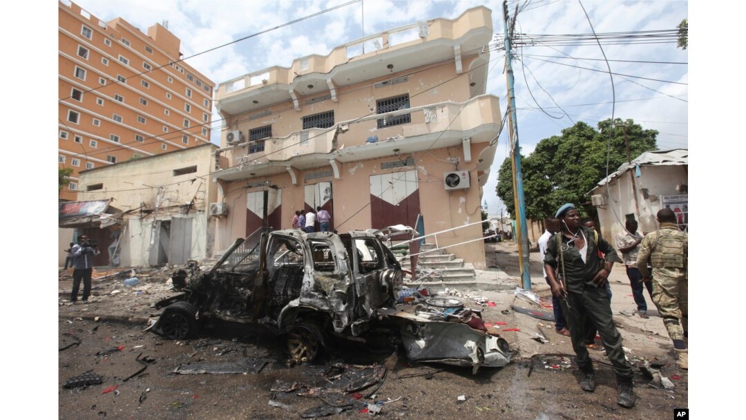 FILE - A Somali soldier stands on guard next to a destroyed car near a popular mall after a car bomb attack in Mogadishu, Somalia, July 30, 2017. The Somalia-based extremist group al-Shabab often carries out deadly bombings in Mogadishu.