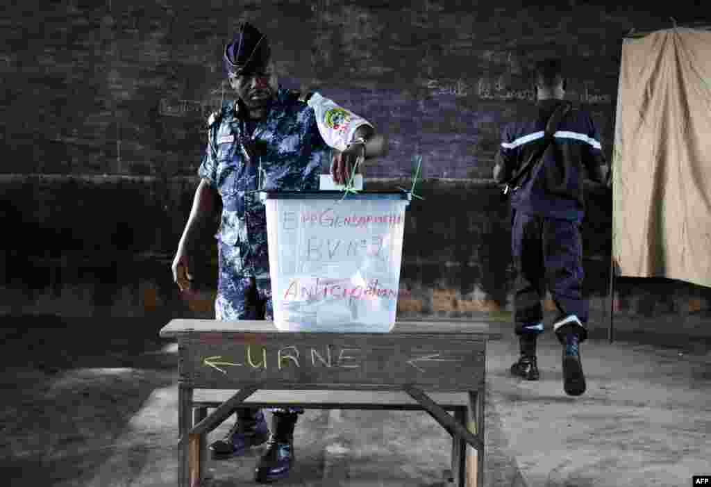 A Togolose gendarme casts his vote for the presidential election at a polling station in Lome, as law enforcement oficers vote 72 hours ahead of the rest of the population. Togo elects a new president Saturday, with the main opposition leader Jean-Pierre Fabre seeking to end nearly 50 years of rule by the Gnassingbe family.