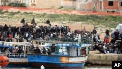 Would-be migrants believed to be from Tunisia are seen on the shores of the Sicilian island of Lampedusa, Italy, after arriving there by boat, February 11, 2011