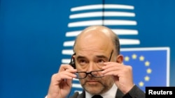 FILE - European Commissioner for economics, taxation and customs Pierre Moscovici attends a press conference after an eurozone finance ministers meeting in Brussels, Dec. 8, 2014. 
