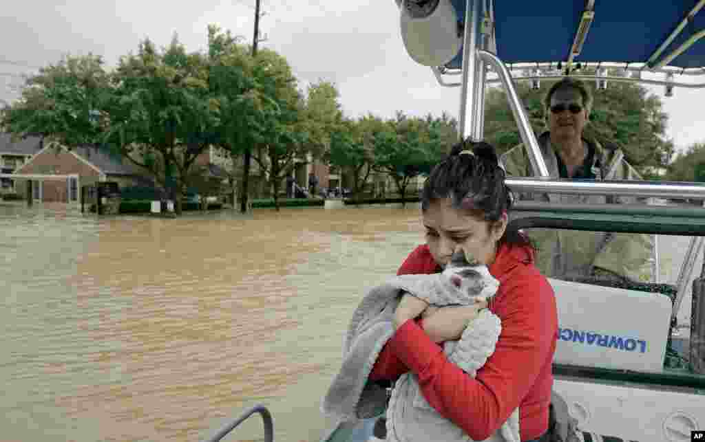 Джанет Мартинез обнимает свою кошку Джиджи, спасаясь из затопленного района, где расположен ее дом, 29 августа 2017, Хьюстон, штат Техас (AP Photo / Charlie Riedel)